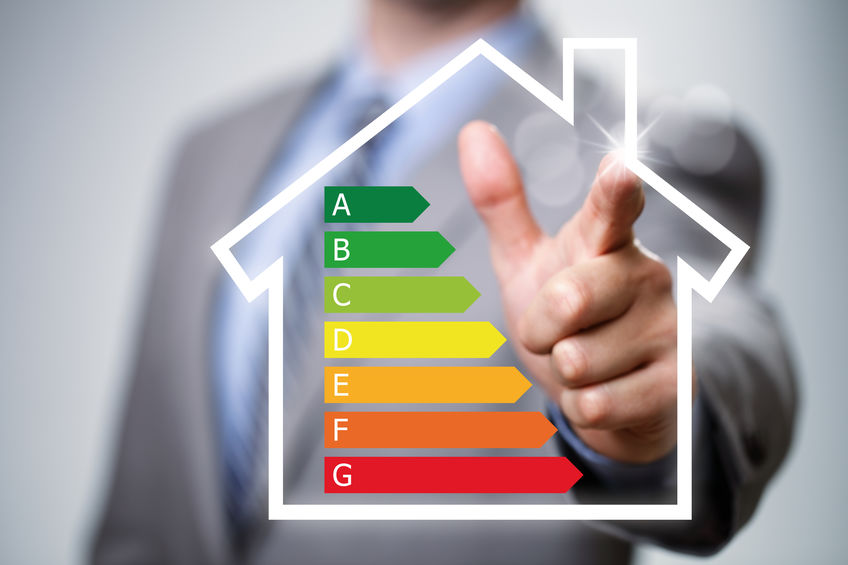 Businessman pointing to energy efficiency rating chart and house icon concept for performance, efficiency and environmental conservation